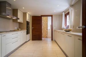 a kitchen with white cabinets and a wooden door at AZUMAR in Santa Eularia des Riu