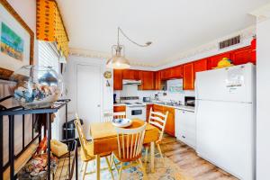 a kitchen with a table and a white refrigerator at Beach Front #203 in Gulf Shores
