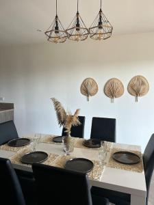 mesa de comedor con sillas y mesa con ventiladores en la pared en Haut de villa sur mer, en Zonza
