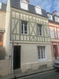 a white and green house with a door at Normandy chérie in Trouville-sur-Mer