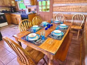einen Holztisch in einer Küche mit Stühlen und einem Tisch in der Unterkunft New Song in Sevierville