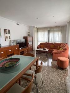 sala de estar con sofá, mesa y sillas en Edificio Columbretes, en Castellón de la Plana