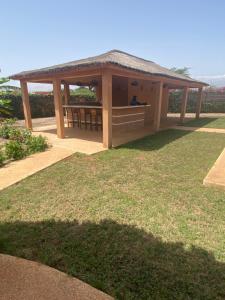einem Holzpavillon mit einem Dach auf einem Rasen in der Unterkunft Magnifica villa con giardino e piscina in Nianing