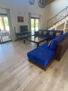 - un salon avec un canapé bleu et une table dans l'établissement Magnifica villa con giardino e piscina, à Nianing