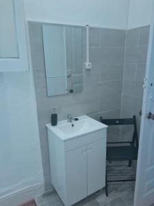 La salle de bains blanche est pourvue d'un lavabo et d'un miroir. dans l'établissement Guesthouse Franco, à Porto