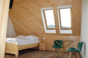 扎科帕内Pokoje Apartamenty Samo Centrum Zakopane ,,Willa Kasztelanka"的一间卧室配有一张床和两张绿色椅子