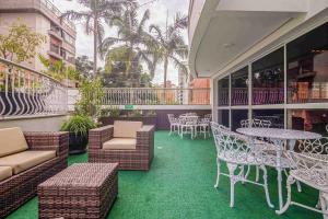 eine Terrasse mit Tischen und Stühlen auf dem Balkon in der Unterkunft Bela Vista Flat in Porto Alegre