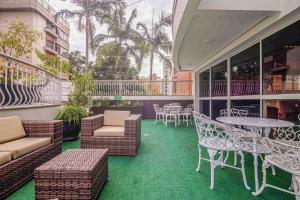 a patio with tables and chairs on a balcony at Bela Vista Hotel & Flat in Porto Alegre