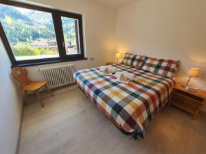 - une chambre avec un lit et une grande fenêtre dans l'établissement Il Rifugio dello Gnomo - Alpine Stay Apartments, à Panchià