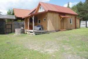 ein kleines Holzhaus mit rotem Dach in der Unterkunft Malowane Wrota in Łazy