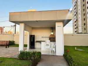a outdoor kitchen with white tables and chairs at Apartamento Cuiabá - Luxxor Flat in Cuiabá