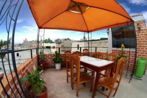 einen Tisch und Stühle mit Sonnenschirm auf einer Terrasse in der Unterkunft Marlon's House Arequipa in Arequipa