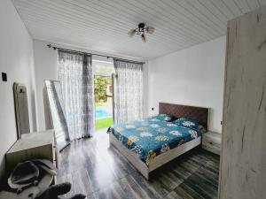 a bedroom with a bed and a large window at Guest house in Lankaran