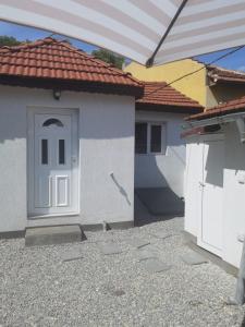 una pequeña casa con una puerta blanca y un techo en Nice house near city center of Ruse, en Ruse