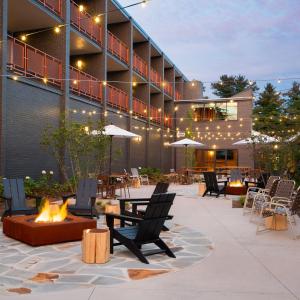 a patio with chairs and a fire pit in front of a building at Rhode's Motor Lodge in Boone