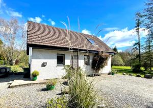 a small white house with a roof at Heronlea Cottage in Dunoon