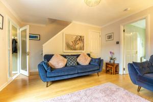 un soggiorno con divano blu e 2 sedie di Inverness Holiday Retreat - 2 Bedroom a Inverness