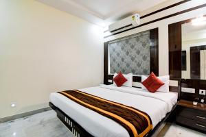 um quarto com uma grande cama branca com almofadas vermelhas em Hotel Trishiv em kolkata