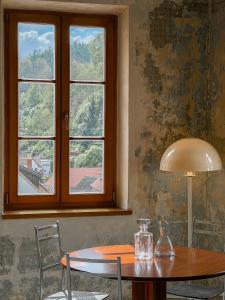 einen Tisch und Stühle in einem Zimmer mit Fenster in der Unterkunft King ROSE by Rose Garden in Český Krumlov