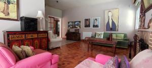 - un salon avec un canapé rose et une table dans l'établissement Mis Tres Centenarios, à El Puerto de Santa María