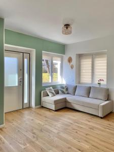 ein Wohnzimmer mit einem weißen Sofa und Holzböden in der Unterkunft Ihost apartment- Guarneri 24 in Mailand