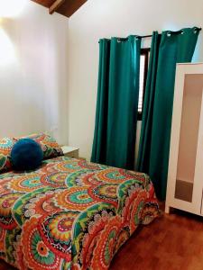 1 dormitorio con cama y cortinas verdes en Chalet en el Palmar solo familias y parejas, en El Palmar