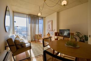 a living room with a dining room table and a television at Aparthotel Oporto Anselmo in Porto