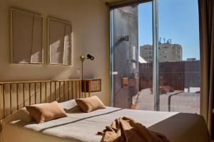 een slaapkamer met een bed en een groot raam bij Aparthotel Oporto Anselmo in Porto