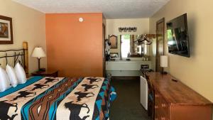 a hotel room with a bed and a sink at Country Mountain Inn in Eureka Springs +12 photos