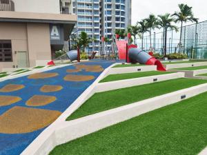 a playground in front of a building with grass at UWen Sylist 2BR Family Suite in Melaka