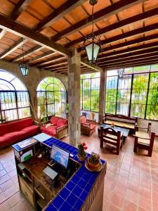 a large living room with red furniture and windows at Mikaso Hotel in San Pedro La Laguna