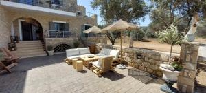 a patio with two chairs and a table and an umbrella at Selinopetra Rooms in Elafonisos