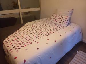 Una cama con corazones de San Valentín. en Le Petit Nid Urbain, en Levallois-Perret