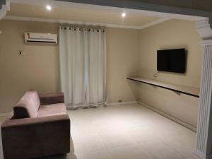 Il comprend un salon doté d'un canapé et d'une télévision à écran plat. dans l'établissement CasaCozy, à Boa Vista