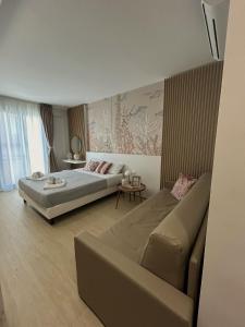 a bedroom with a bed and a couch at Memo - Mediterranean Emotions in San Vito lo Capo