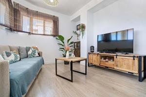 een woonkamer met een bank en een flatscreen-tv bij Apartamento Faro 1 in Roquetas de Mar