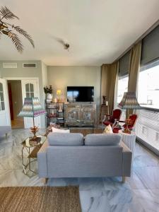 a living room with a couch and a tv at Apartamento Virgen de la Victoria in Seville