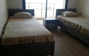 - 2 lits jumeaux dans une chambre avec fenêtre dans l'établissement LE GRANd BLEU - ONLY FAMILIES, à Sidi Bouqnadel