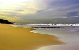 une plage de sable avec des vagues dans l'océan dans l'établissement LE GRANd BLEU - ONLY FAMILIES, à Sidi Bouqnadel