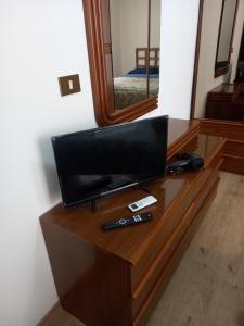 - une télévision sur une commode dans une pièce avec un miroir dans l'établissement Casa turistica Santa Lucia 25, à Regalbuto