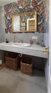 a bathroom with a sink and a mirror and baskets at Apartamento Virgen de la Victoria in Seville +19 photos