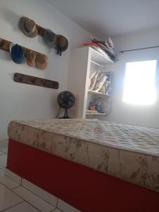 un letto in una stanza con finestra e alcune scarpe di Apartamento a Beira Mar a Jaguaruna