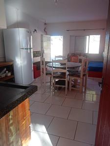 kuchnia ze stołem i lodówką w obiekcie Apartamento a Beira Mar w mieście Jaguaruna
