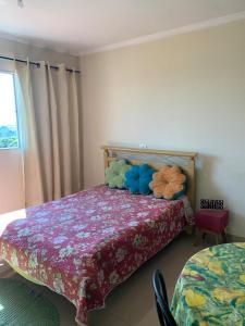 Pousada Villa Argos Guesthouse في بيراسيكابا: غرفة نوم مع سرير مع لحاف جميل