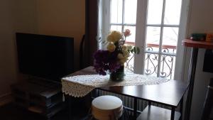 un jarrón de flores en una mesa frente a una ventana en Le Petit Nid Urbain, en Levallois-Perret