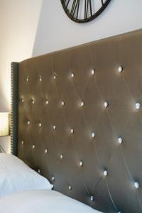 1 cama con cabecero marrón y reloj en la pared en Lux Modern Apt Ανακαινισμένο διαμέρισμα 150m από την πλαζ 'ΈΔΕΜ', en Atenas