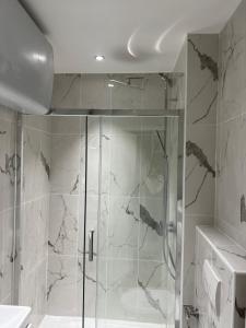 y baño con ducha y puerta de cristal. en Quartierlatin apartment en París
