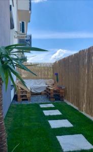 un patio trasero con una valla, una mesa y césped en Apartament Radiana, en Băile Felix