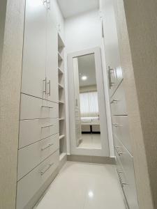 vestidor con armarios blancos y espejo en Exclusivo departamento en condominio con Piscina, en Piura