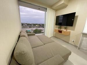 sala de estar con sofá y ventana grande en Exclusivo departamento en condominio con Piscina, en Piura